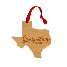 Wooden Texas shaped ornament with Georgetown on it and a red ribbon hanger
